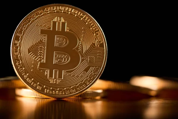 Gyllene bitcoin som huvudsakliga digital valuta i världen presenteras på suddig bakgrund med andra kryptovalutor. — Stockfoto