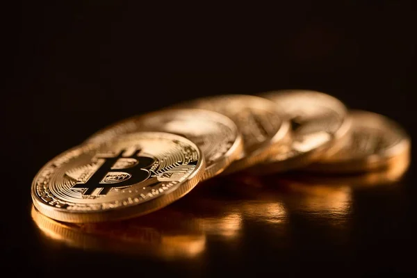 Rad av glänsande gyllene bitcoins som huvudsakliga digital valuta nuförtiden isolerad på svart bakgrund — Stockfoto