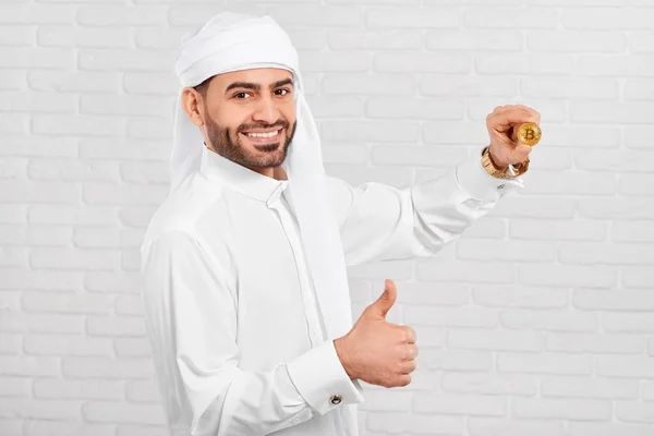 Studio fotografii uśmiechający się Arabian biznesmena utrzymuje bitcoin. — Zdjęcie stockowe