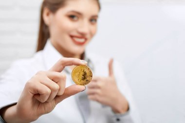Bir işkadını giyiyor kıyafet kodu portresi altın bitcoin tutar.