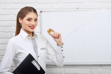 Güzel işkadını giyen üniforma altın madeni para tutar.