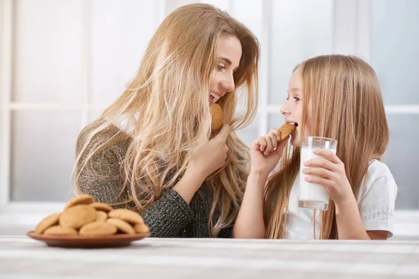 Portarait de surori mai mari și mai mici care mănâncă cookie-uri și zâmbet . — Fotografie, imagine de stoc