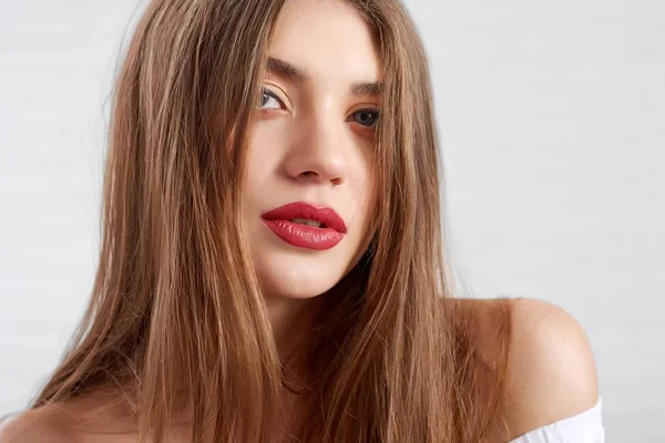 Modelo atractivo caucásico con maquillaje de ojos y lápiz labial rojo mirando a la cámara mientras posan — Foto de Stock