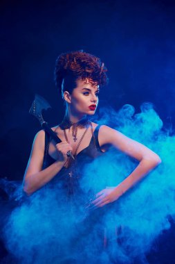 Duman bulutu içinde keskin balta ile tehlikeli kız duruyor.