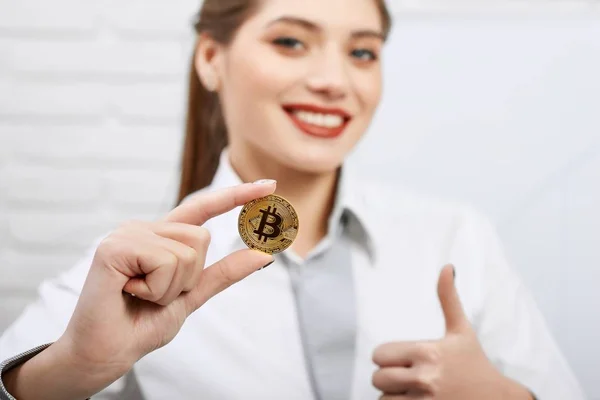 Linda mulher sorridente segurando bitcoin dourado e mostrando os polegares para cima — Fotografia de Stock