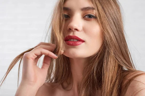 Modelo caucásico con maquillaje de ojos y lápiz labial rojo mirando juguetonamente a la cámara — Foto de Stock