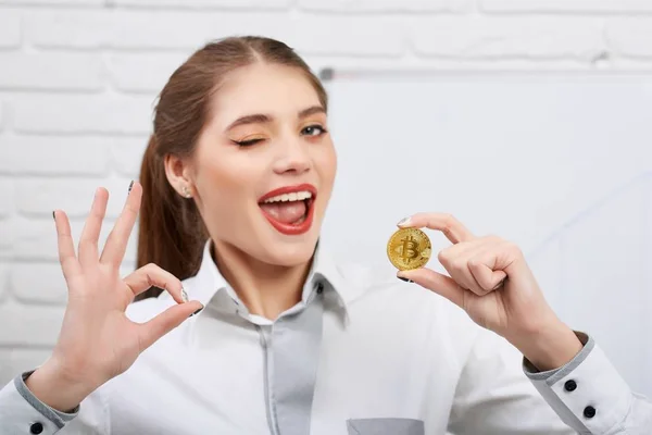 Attractive young model holding golden bitcoin and showing ok sign — Stock Photo, Image