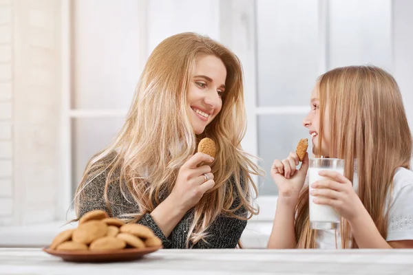 Portarait de surori mai mari și mai mici care mănâncă cookie-uri și zâmbet . — Fotografie, imagine de stoc