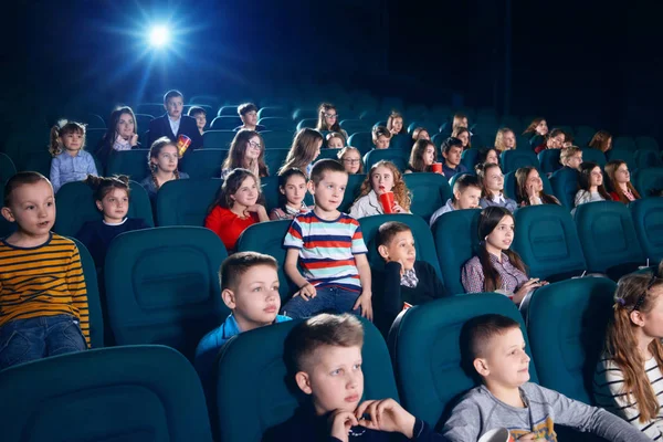 Vista laterale delle persone che guardano film nella sala del cinema . — Foto Stock