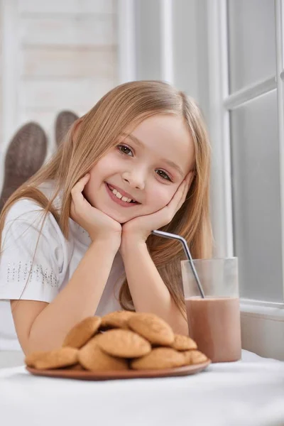Znakomity, mała dziewczynka z ciasteczka i mleko czekoladowe. — Zdjęcie stockowe