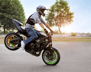 Motosiklet güneşli Caddesi üzerinde oturan motorcu.