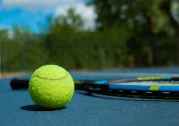 Close up of tennis ball on professional racket background.