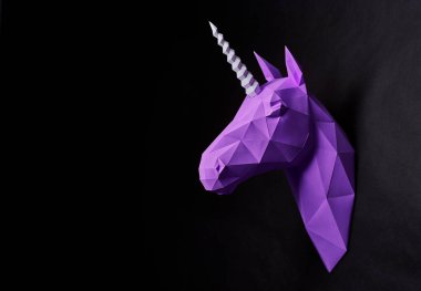 Sideview of bright violet unicorns head hanging on wall. clipart