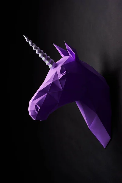 Deep shadowed violet unicorns head profile hanging on contrast wall. — Stock Photo, Image