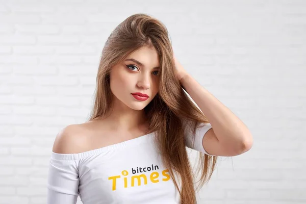 Beautiful female model in white crop top with bitcoin logo posing to camera — Stock Photo, Image