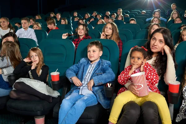 Anya néz film a moziban gyerekekkel. — Stock Fotó