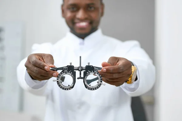 Sorrindo homem dando lentes médicas para experimentar . — Fotografia de Stock