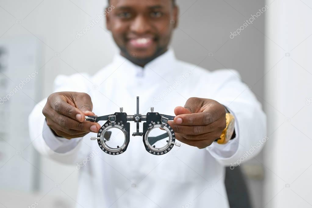 Smiling man giving medical lenses to try on.