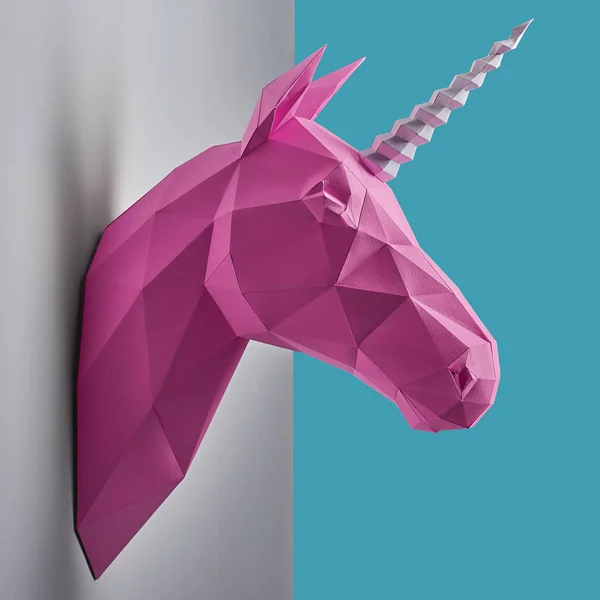 Bright pink unicorn hanging on the contrast white and blue wall. — Stock Photo, Image