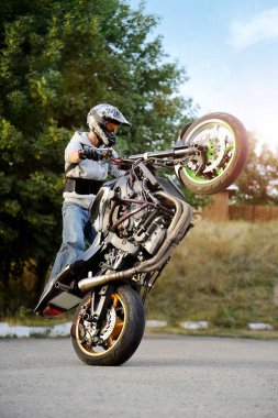 Güçlü bisikletçinin gösteren aşırı dublör bir tekerlek üzerinde.