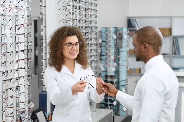 Junge Augenärztin hilft bei der Wahl der richtigen Brille. — Stockfoto