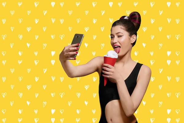 Pop art model eating ice cream, taking selfie.