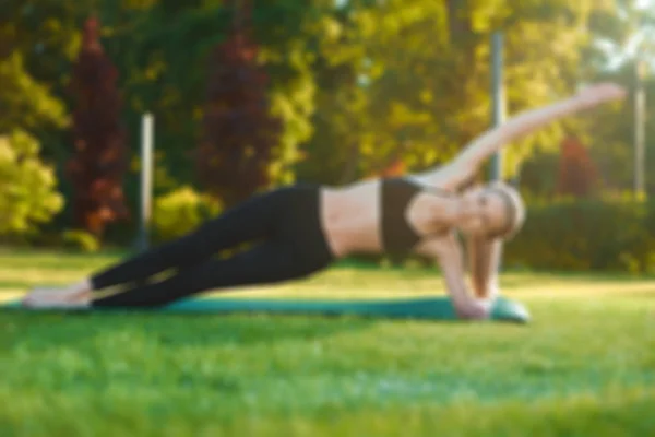 Photo floue de la femme faisant du yoga dans le parc . — Photo