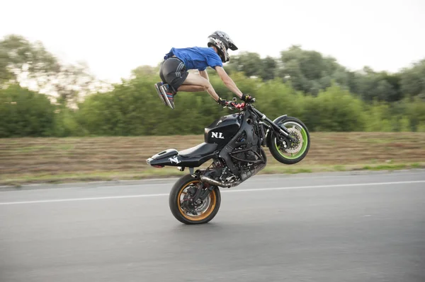 Foto de movendo bravo motociclista em pé na motocicleta durante a equitação . — Fotografia de Stock