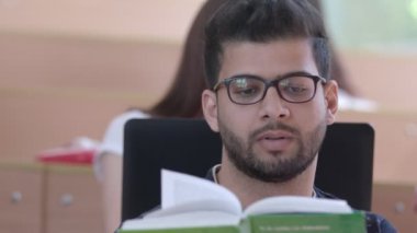 Öğrenci üniversite sınıf sırasında okuma sakallı.