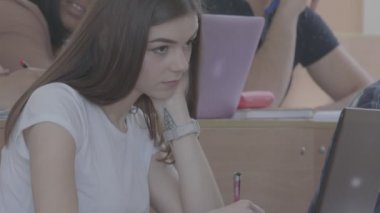 Sınıfta grup arka plan üzerinde oturan kız.