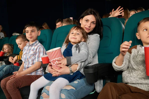 Nő és gyermek ül a film-színház, és pózol a kamera. — Stock Fotó