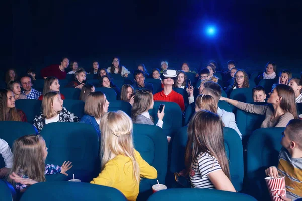 Люди смотрят на мальчика в виртуальных очках в кинотеатре . — стоковое фото