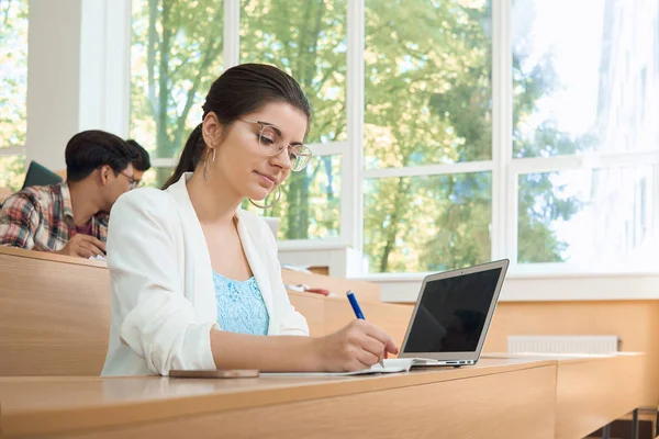 Estudiante joven que estudia en la universidad trabajando con portátil . — Foto de Stock