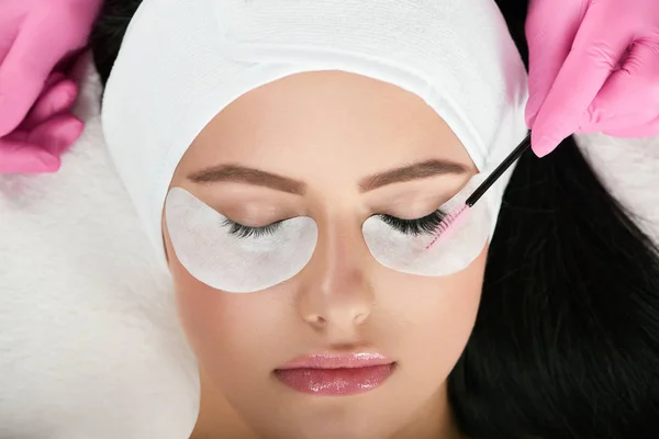 young model with pretty face lying during lashes enlarging.