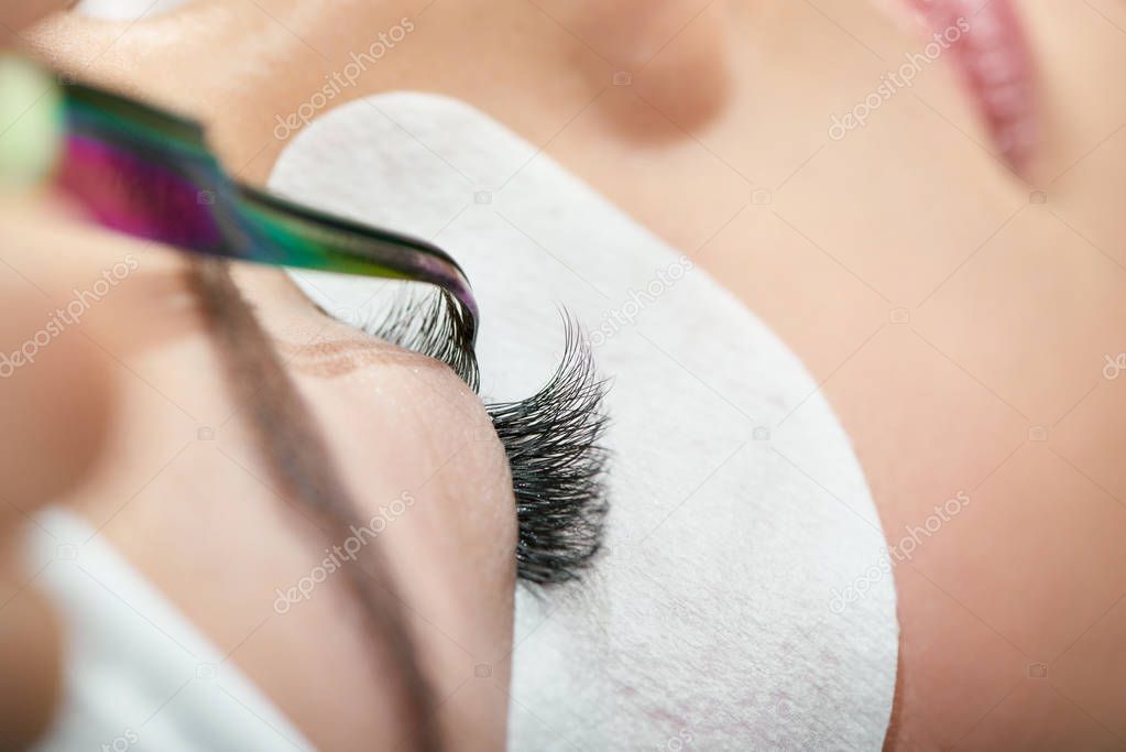 Close up of making lashes with tweezers.