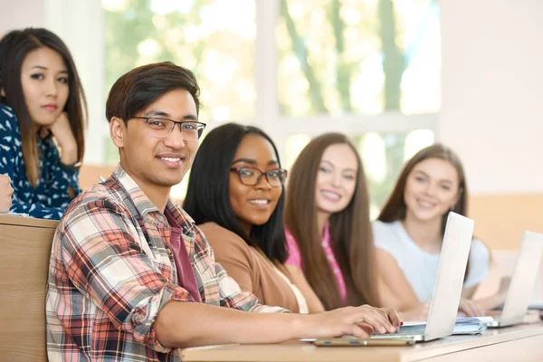 Vista laterale dei compagni di gruppo che guardano la telecamera seduta all'università . — Foto Stock