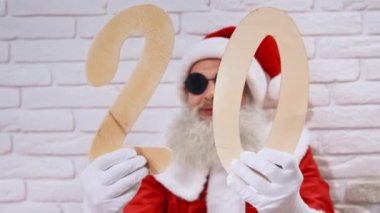 Sakallı Noel Baba 'nın portresi 20 ahşap sayı tutuyor.
