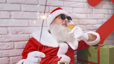 Gri sakallı Noel Baba stüdyoda şampanya içiyor.