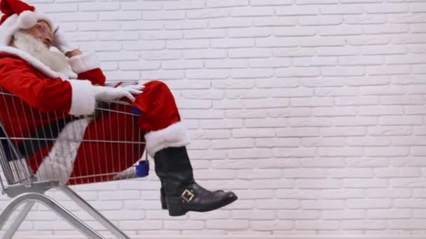 Senior Saint Nicholas sedí uvnitř nákupního košíku — Stock video