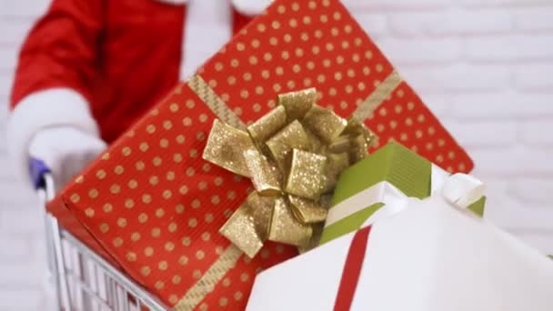 Weihnachtsmann mit Einkaufswagen voller bunter Geschenkboxen — Stockvideo