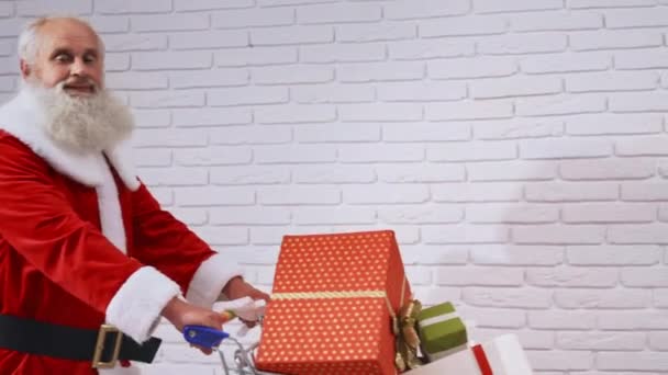 Vousatý Santa Claus tlačí nákupní vozík s dárky — Stock video