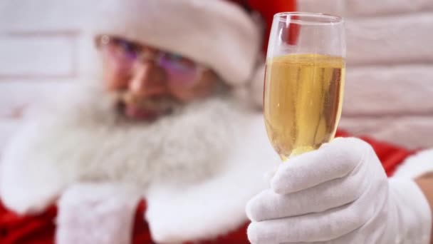 Święty Mikołaj ze szklanką szampana i kciukiem do góry w studio — Wideo stockowe