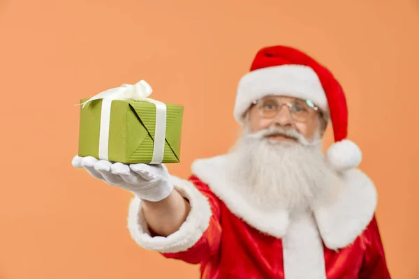 Santa Claus in white gloves holding christmas present — Stock Photo, Image