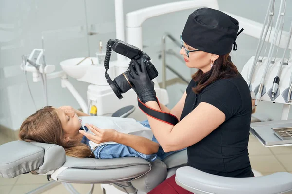 Dentista inspeccionando los dientes de la joven . — Foto de Stock