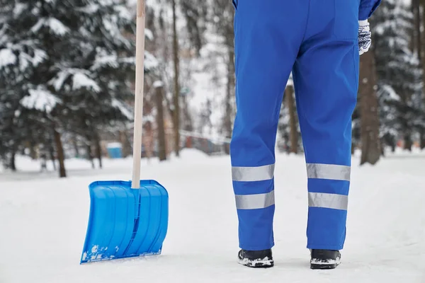 Обрізаний прибиральник з лопатою на снігу в парку . — стокове фото