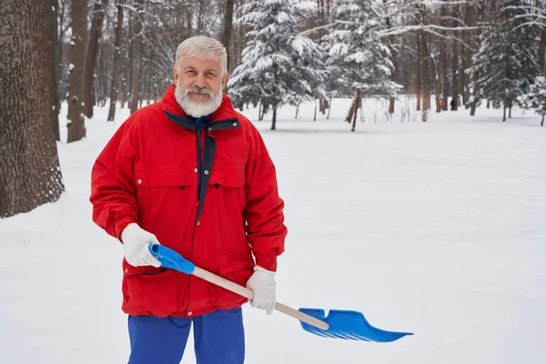 Férfi takarítás hó chovel a parkban. — Stock Fotó