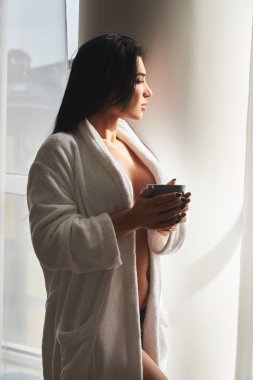 Sabahlık giyip kahve içen baştan çıkarıcı, çıplak kadın.