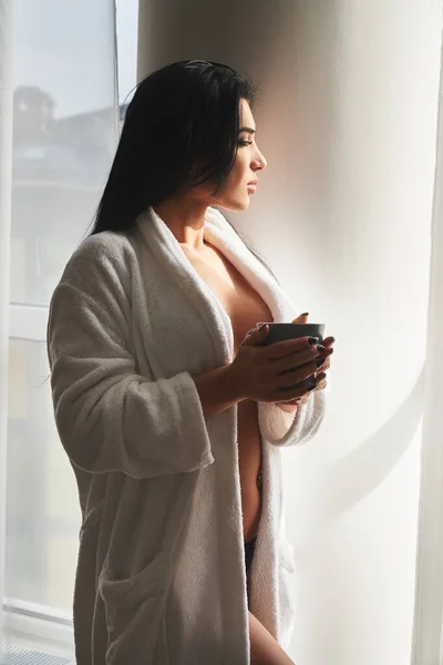 Seductive naked woman in dressing gown and drinking coffee — Stockfoto