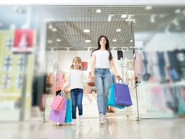 Hija de la mano de la madre y salir de la tienda — Foto de Stock