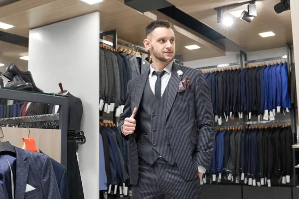 Cavalheiro posando de terno em showroom de boutique . — Fotografia de Stock